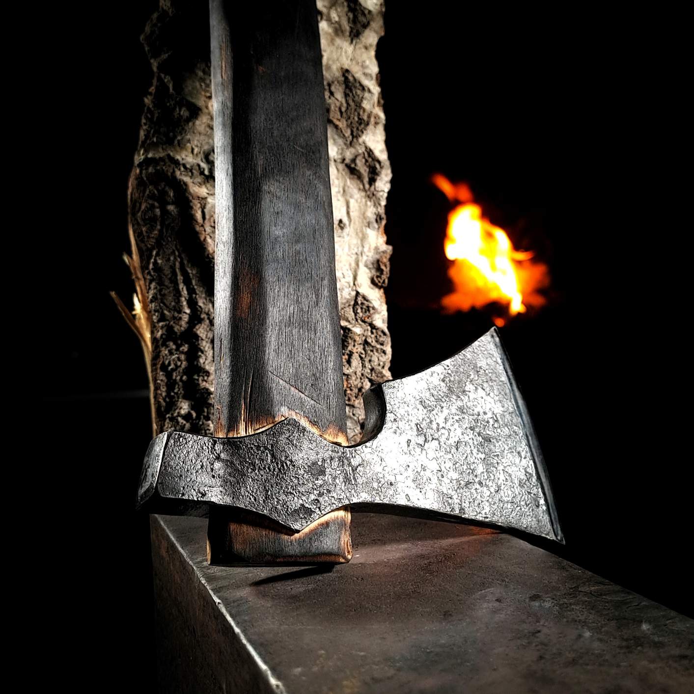 A close-up photo of a hand-forged authentic Viking axe in a. The axe head is forged from high-carbon steel and the handle is made from carefully selected hardwood.