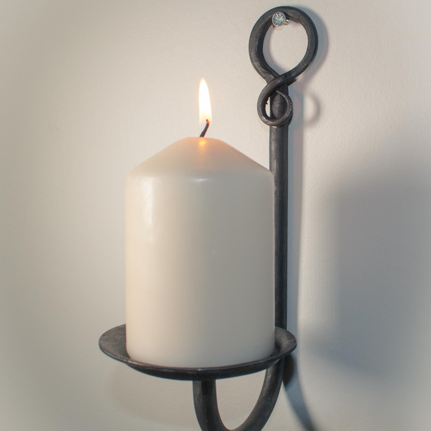 Decorative iron candle holder with a rustic finish and elegant craftsmanship.
