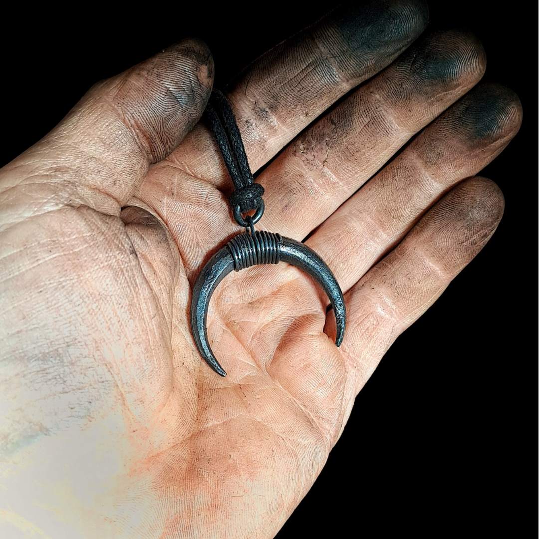 holding a iron moon pendant in hand